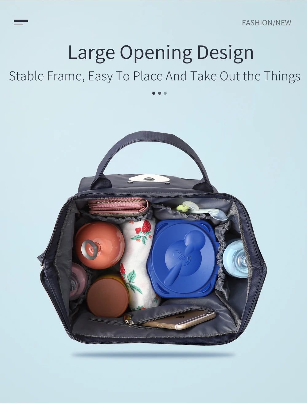 A dark gray waterproof diaper backpack with an interior changing mat, various accessories, and a smartphone visible.