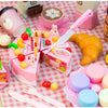 A pink pretend play tea party set featuring coffee cups, cakes, and other food items for children.