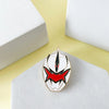 An enamel pin featuring a red and black dinosaur battle suit and helmet design on a white background.
