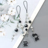 Silver and black anime-inspired keychain featuring various charms including a face and a star.