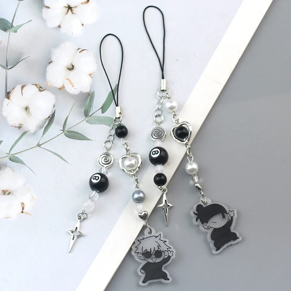Silver and black anime-inspired keychain featuring various charms including a face and a star.