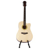 A light-colored acoustic guitar is displayed on a foldable metal stand.