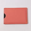 A slim card holder wallet in coral pink leather with a black cat silhouette on the front.