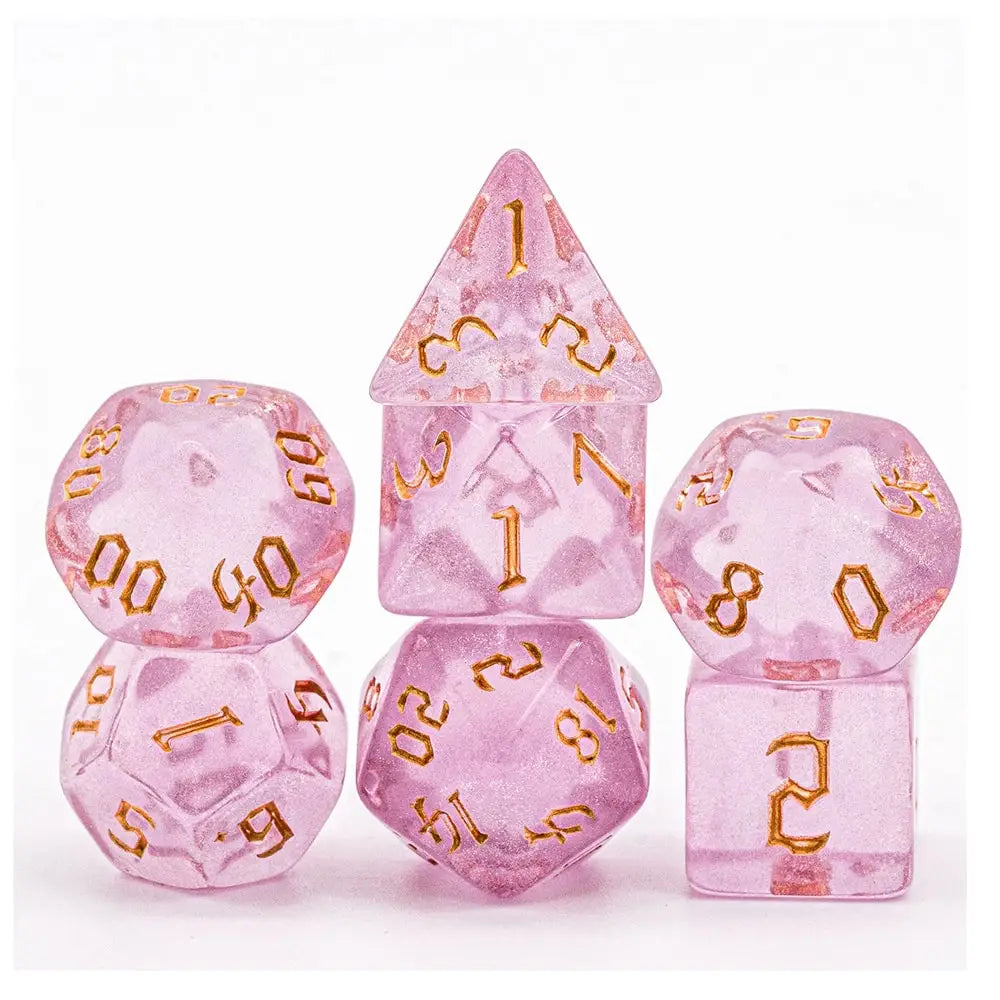 A set of seven translucent pink glitter polyhedral dice, including a tetrahedron and a cube.