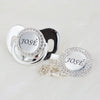 A silver crystal pacifier and clip gift set featuring a circular pendant engraved with the name José