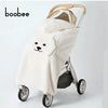 A beige baby windproof cape blanket with a dinosaur design is shown on a stroller.