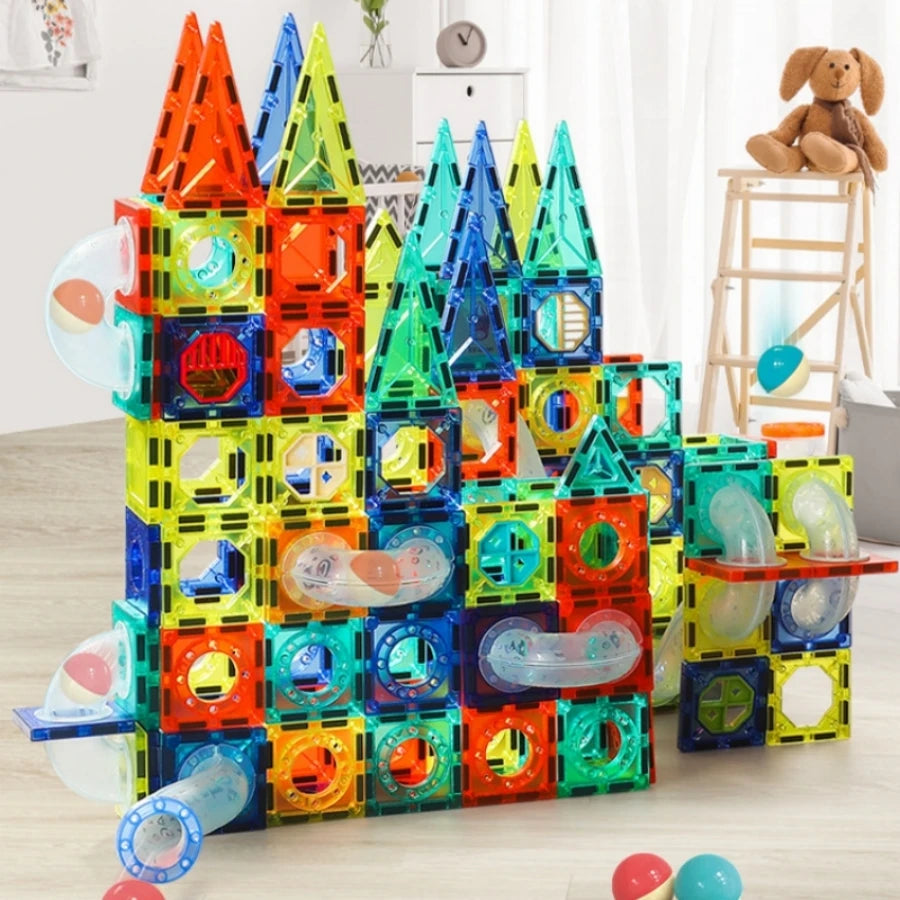 A colorful magnetic pipe building blocks set stacked into a castle structure on a wooden floor.
