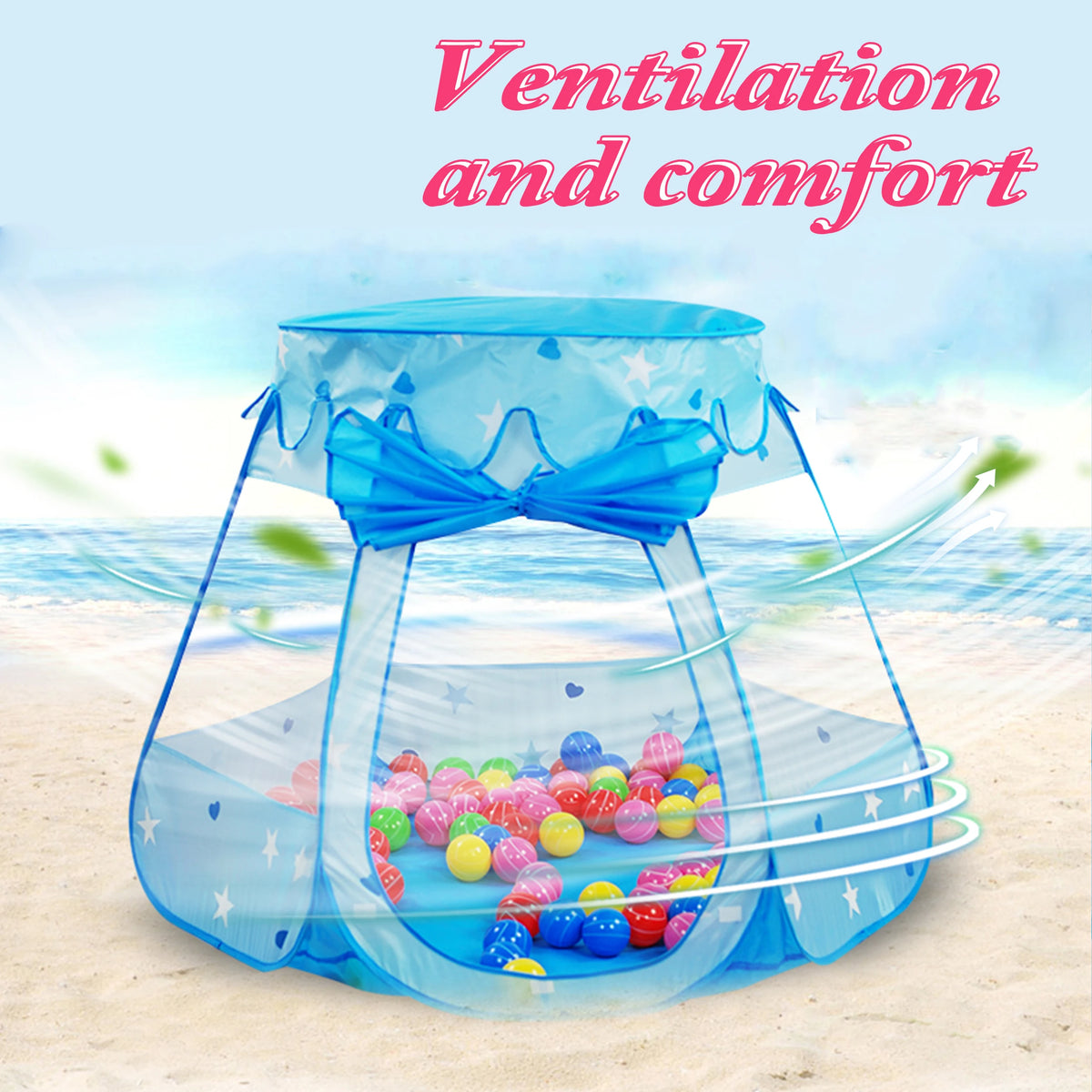 A blue mesh play tent with a bow, filled with colorful plastic balls, set up on a sandy beach.