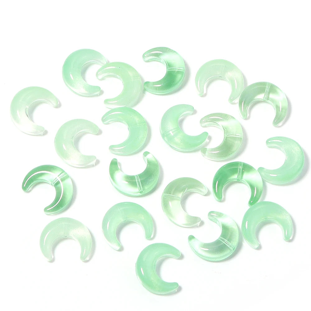 A collection of translucent green moon-shaped glass beads for DIY jewelry making
