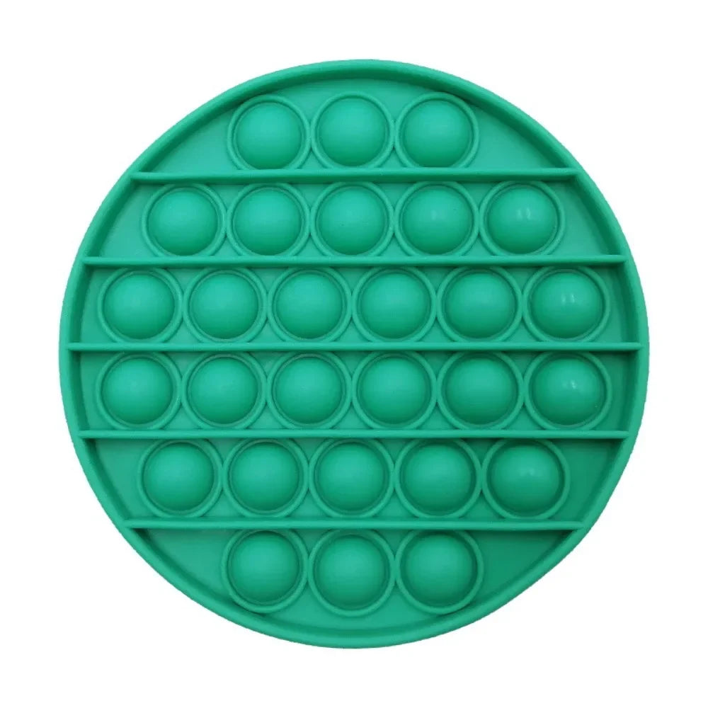 A circular green silicone fidget toy with multiple raised bubbles for sensory play and stress relief.