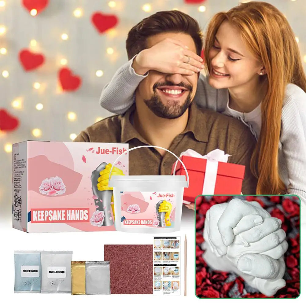 A man and woman are posing for a photo while holding a pink box of a 3D hand and foot print casting kit.