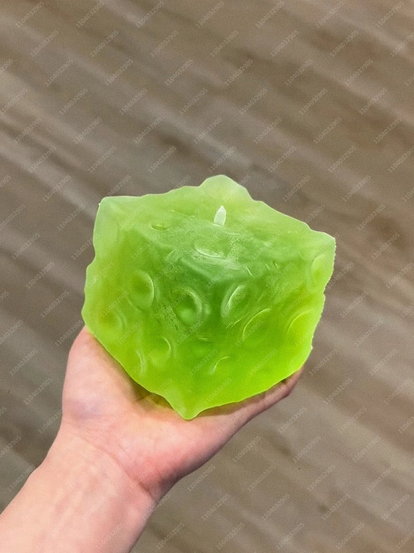 A hand holds a translucent lime green frosted matte jumbo stress ball against a neutral background.