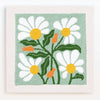 A punch needle embroidery kit featuring a light green background with white and yellow daisy flowers and orange stems.