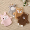 Three plush animal toys, including a gray sheep, an orange fox, and a brown bear, lying on a beige fabric.