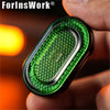 A hand holds a green metal mechanical fidget slider with a diamond gem design.