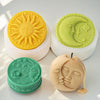 Silicone molds of a sun and moon face in yellow, green, and beige for candles and soap making