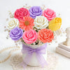 A bouquet of pink and purple silicone flower molds arranged in a white vase on lace