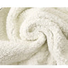 Close-up of a white fleece fabric with a soft, curly texture and subtle polka dot pattern.
