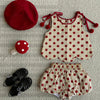 A two-piece girls summer set featuring a red and white polka dot print top and matching shorts, with a red hat and black shoe