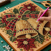A close-up of a diamond painting artwork featuring intricate red, green, and gold floral designs on a canvas.