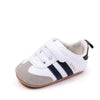 A pair of white baby first walkers shoes with gray and black stripes and a beige lining.