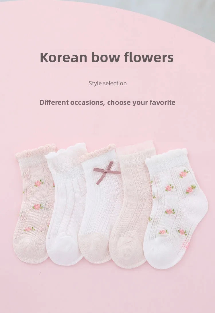 A selection of five pairs of light pink and white floral cotton socks displayed on a pink background.