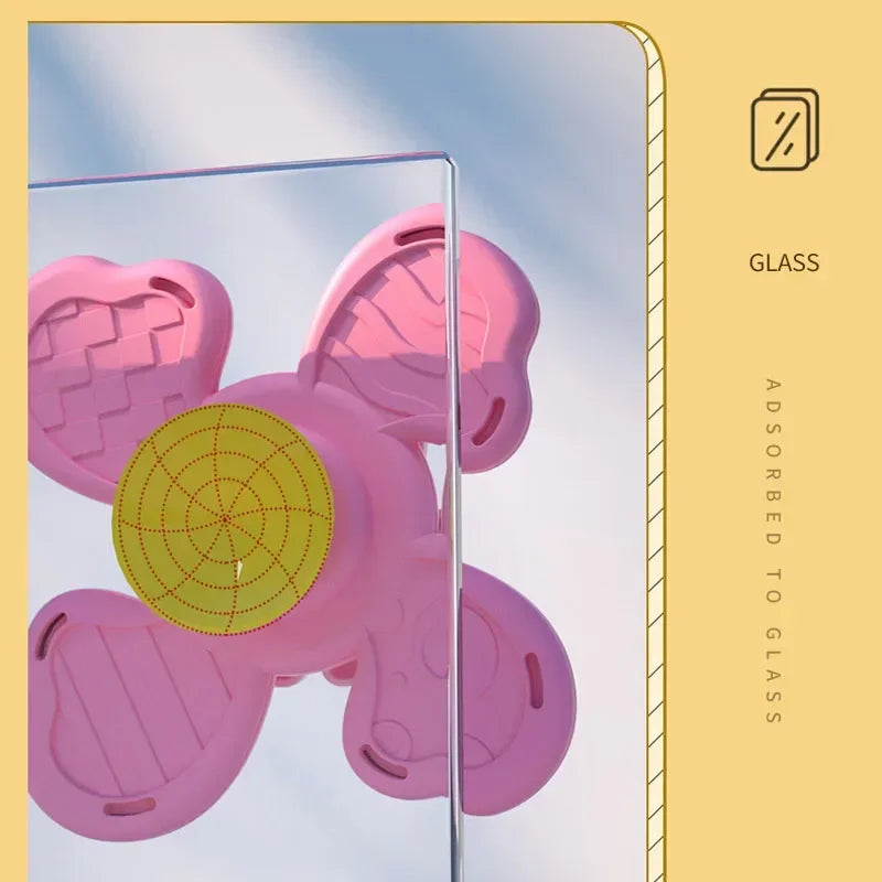 Pink suction cup spinner bath toys are shown against a light background with a glass surface.
