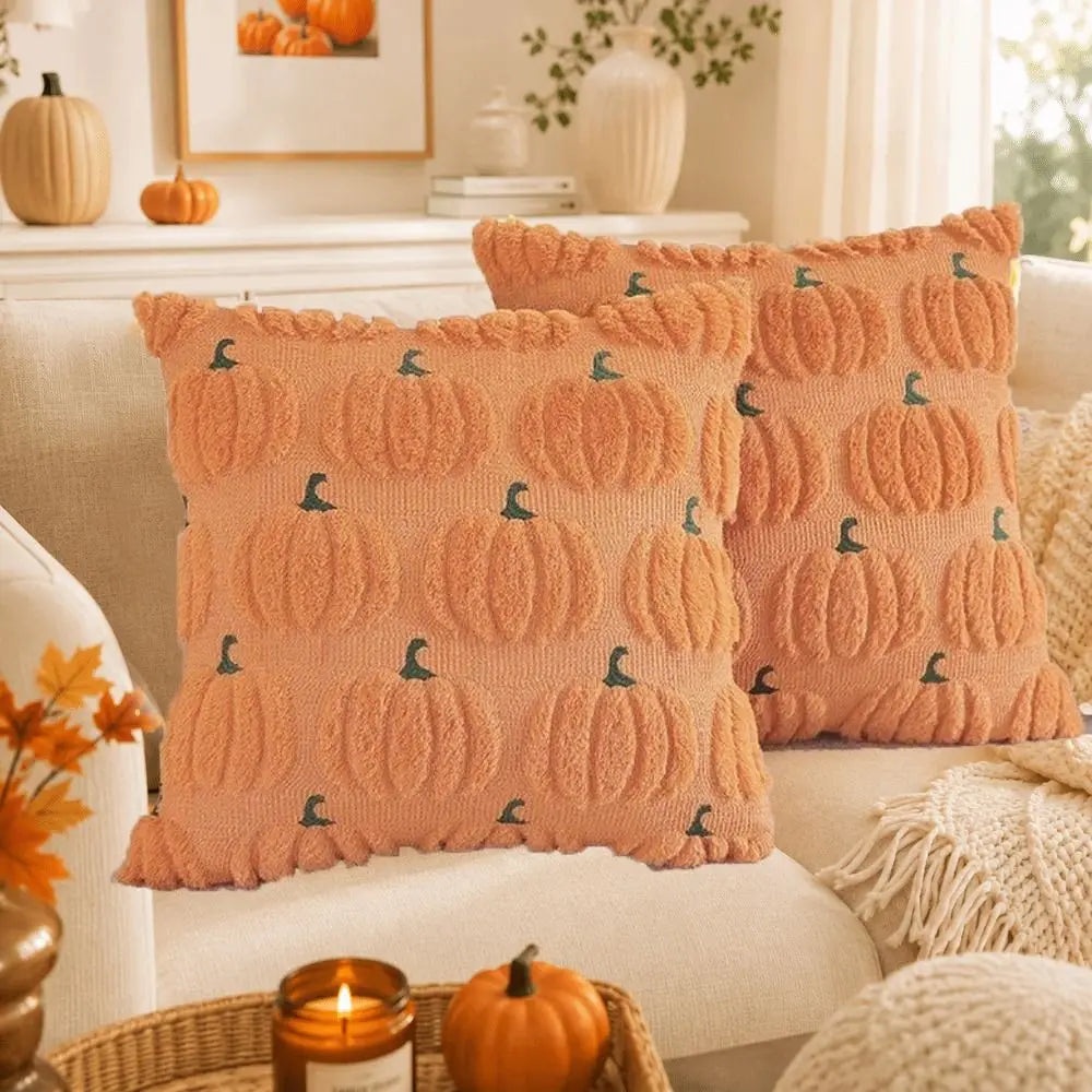 A set of orange pumpkin patterned Halloween pillow covers displayed on a sofa.