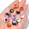 A collection of orange, black, purple, and white acrylic beads featuring Halloween designs like bats, cats, and skulls.