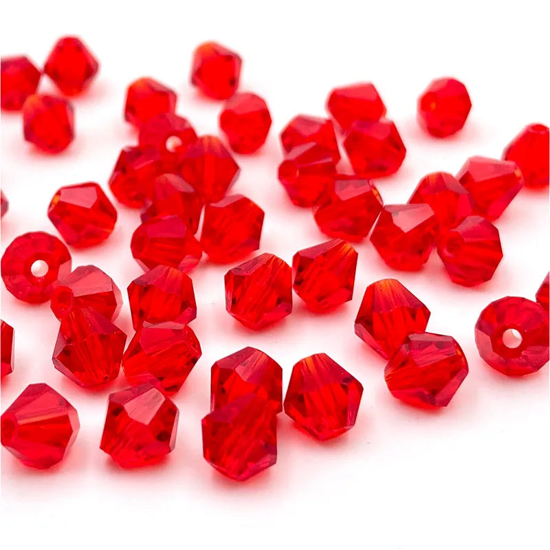A pile of faceted red crystal glass beads in various sizes and shapes for jewelry making