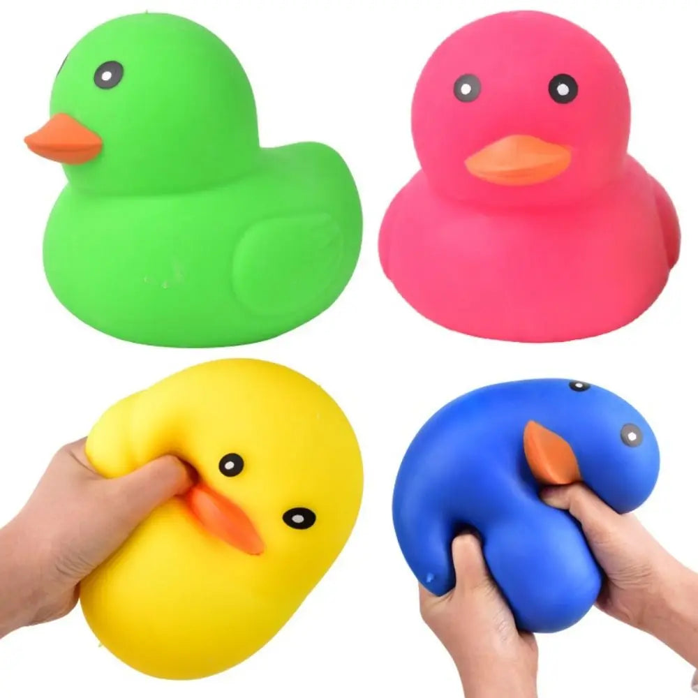 A set of three colorful squeeze duck stress relief toys in green, pink, and yellow being held by a hand.