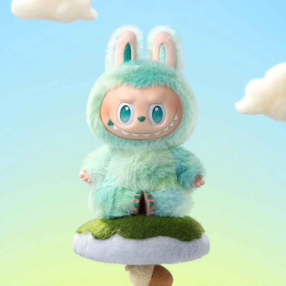 A light blue fluffy plush doll of Labubu The Monsters Big Into Energy sitting on a green mossy base against a light blue sky 