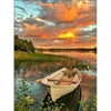 A wooden boat floats on calm water under a vibrant sunset sky with orange and pink clouds.