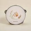 A round wooden tambourine with a painted bear illustration and gold accents.