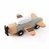 A wooden train toy featuring a gray body, white cockpit, and light wood accents with black wheels.