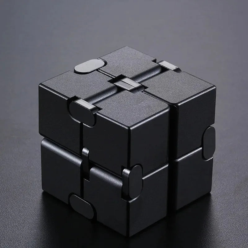 Cube anti-stress en métal noir à infini avec pièces emboîtables, vue de dessus.