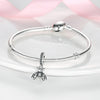 A sterling silver bracelet with a charm bead is displayed on a white surface.