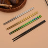A set of six stainless steel chopsticks and dinnerware resting on a neutral background.
