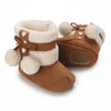 A pair of brown animal-themed baby first walker shoes with light fur trim and leather accents.