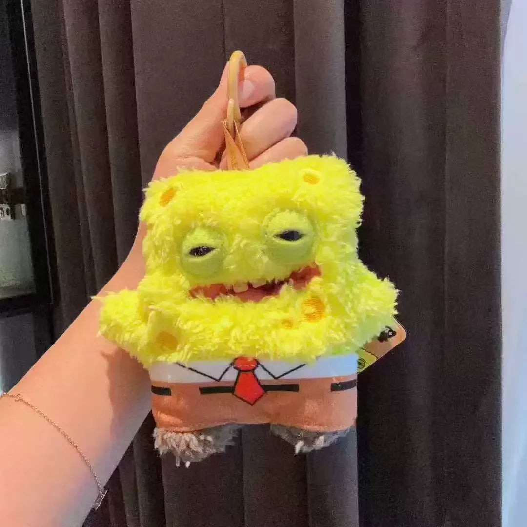 A yellow, fuzzy monster plush keychain resembling SpongeBob SquarePants is held in a person's hand.