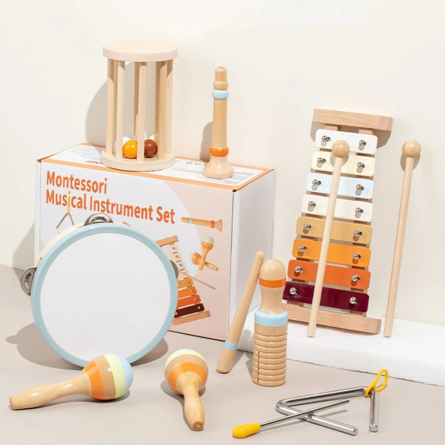 A set of wooden musical instruments including a hand bell, maracas, and other wooden toys for sensory play.