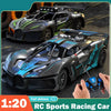 A black and green RC sports racing car is shown in a close-up, being held by a hand.