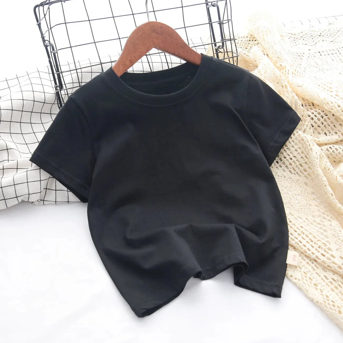 Black classic cotton crew neck t-shirt for kids displayed on a white surface.