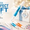 A white diamond painting pen is shown next to a gift box and several other pens on a surface.