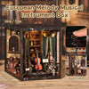 An open wooden box kit of a European Melody Musical Instrument Box featuring various musical instruments and decorative eleme