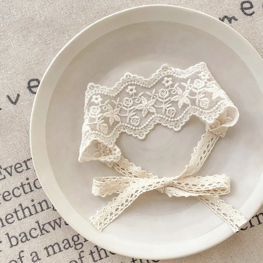 White floral lace baby headband for newborns displayed on a light background.