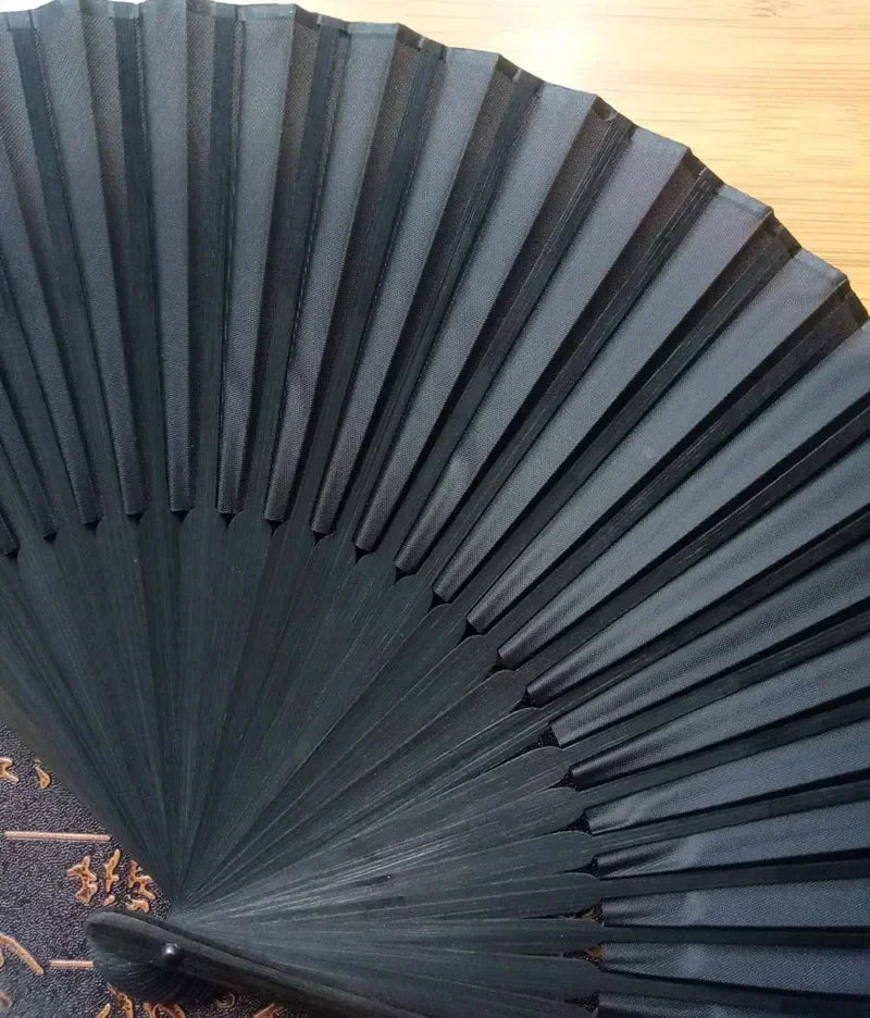 Elegant black folding hand fan with bamboo frame shown in a fan shape.