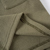 A close-up of a olive green knit outfit set featuring a textured tee and shorts.