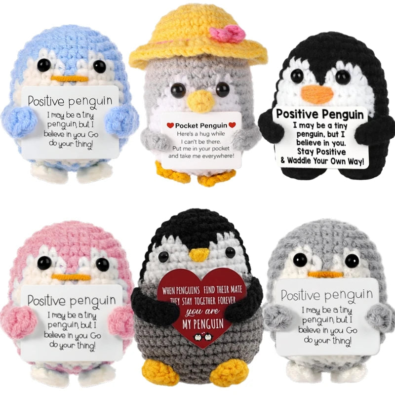 Handmade crochet penguin dolls with positive messages on cards in various colors