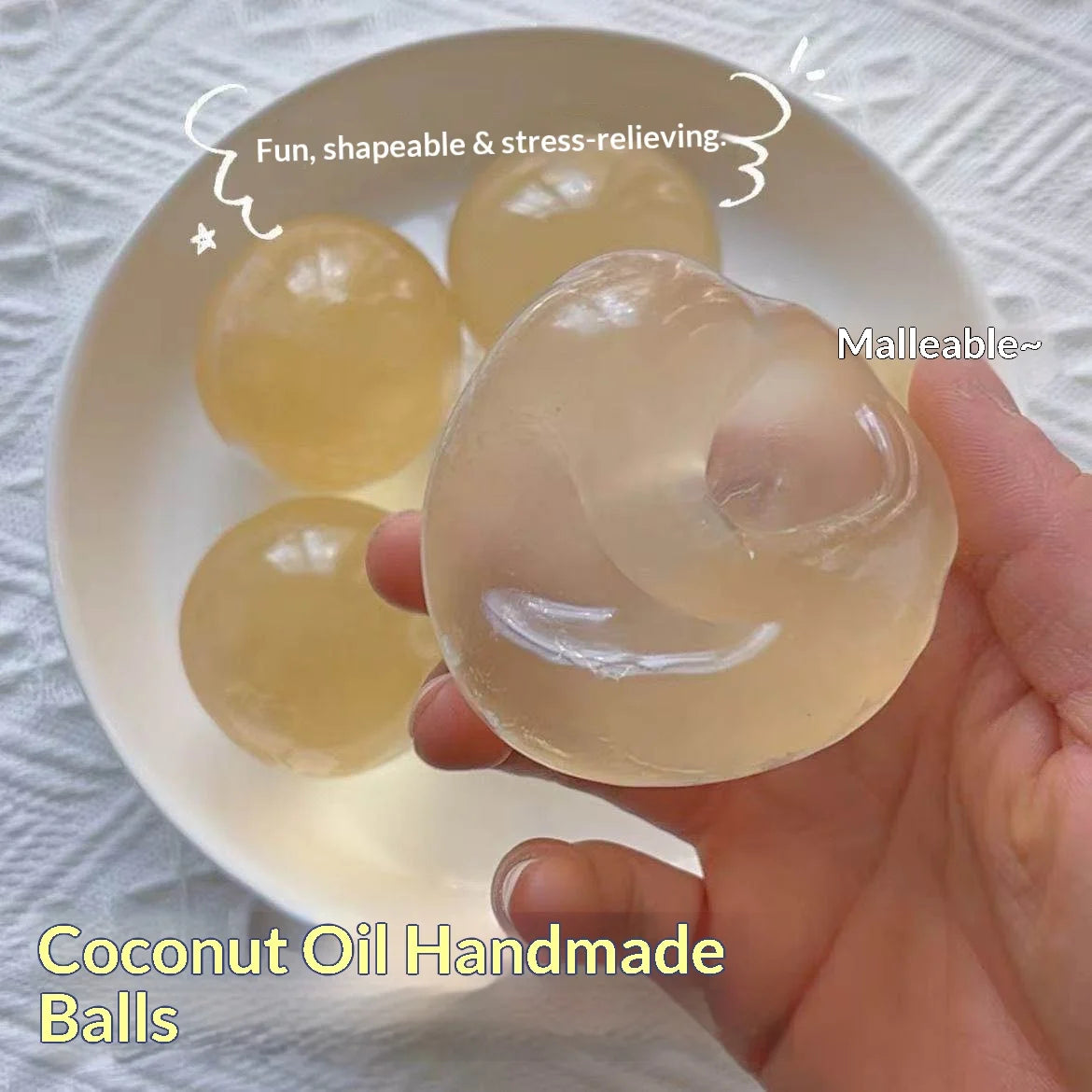 A hand holds a translucent yellow coconut oil handmade ball on a white plate.